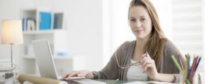 young woman at computer looking into camera